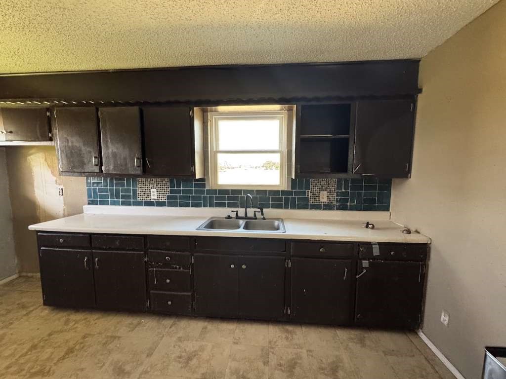 2605 East 19th Street Lubbock, TX 79403 - Photo 5 of 10 a view of a kitchen counter space a sink a window and cabinets