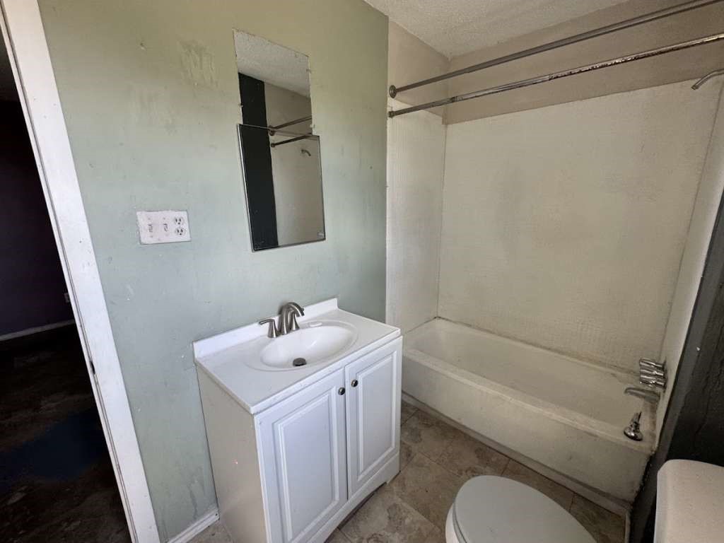 2605 East 19th Street Lubbock, TX 79403 - Photo 8 of 10 a bathroom with a sink a toilet and shower