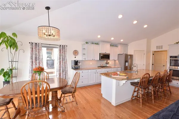 a view of a dining room with furniture wooden floor and a chandelier