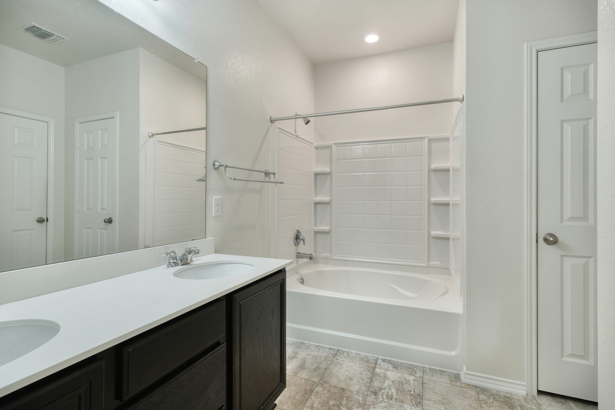 13813 James Garfield Street Manor, TX 78653 - Photo 12 of 13 a bathroom with a bathtub shower sink vanity and a mirror