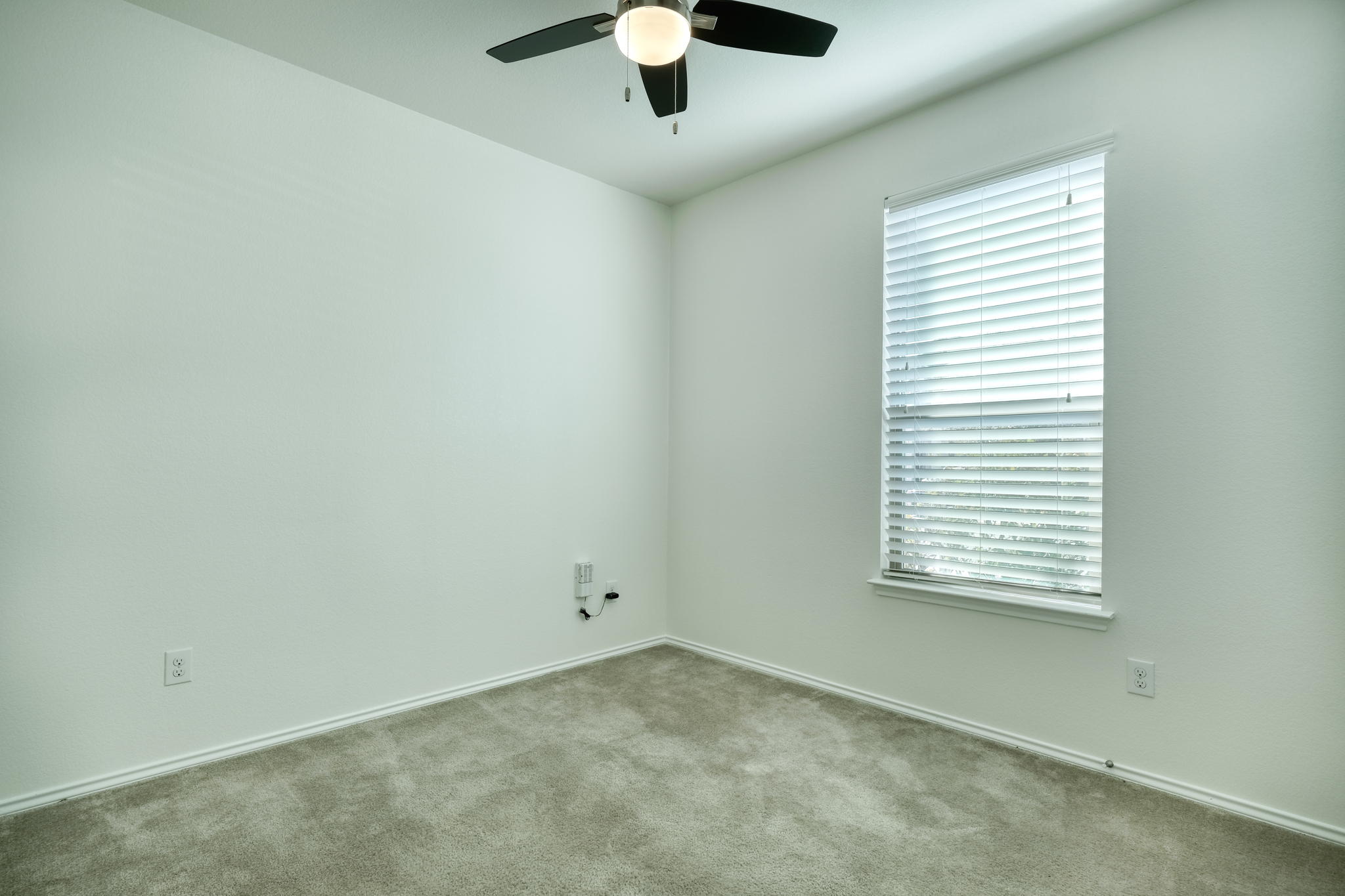 13813 James Garfield Street Manor, TX 78653 - Photo 3 of 13 an empty room with a window and a ceiling fan