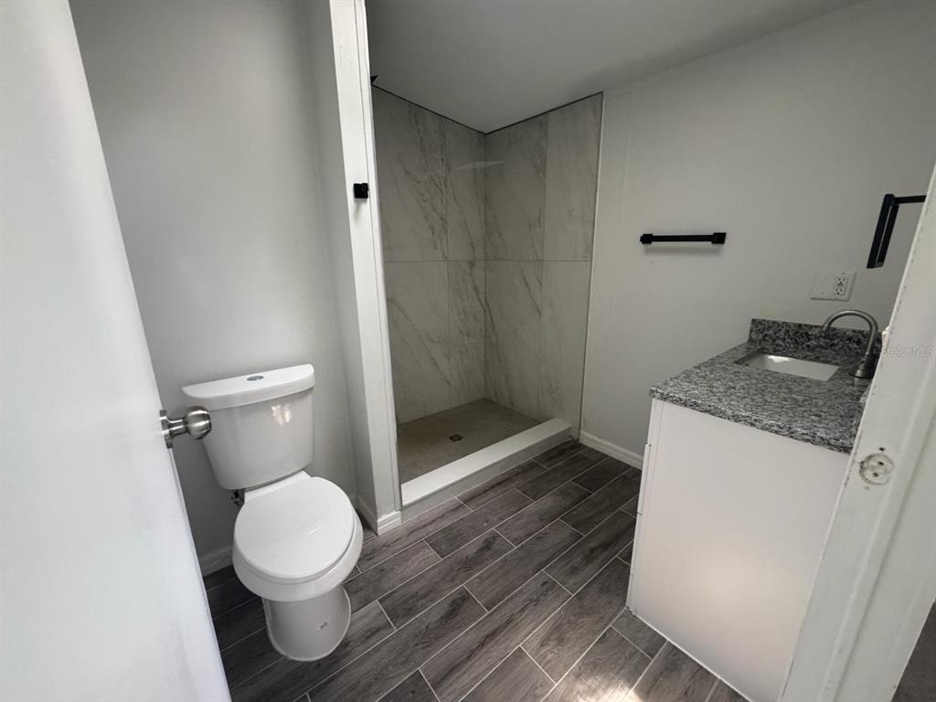 9053 Bourbon Street New Port Richey, FL 34654 - Photo 17 of 27 a bathroom with a granite countertop sink toilet and shower