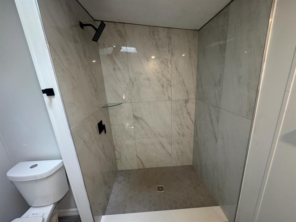 9053 Bourbon Street New Port Richey, FL 34654 - Photo 18 of 27 a bathroom with a shower and toilet