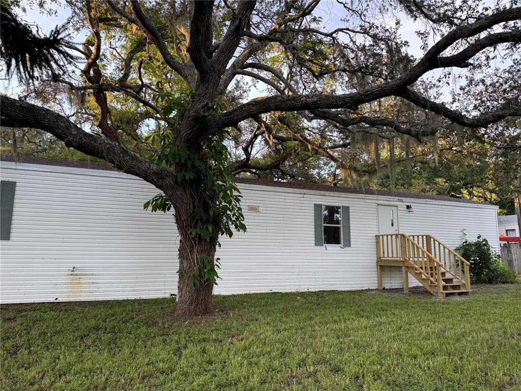 9053 Bourbon Street New Port Richey, FL 34654 - Photo 2 of 27 a white house that has a tree in front of the house