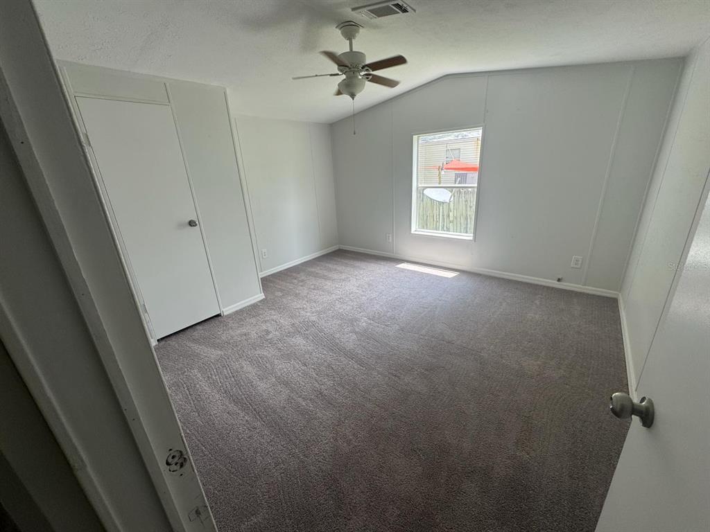 9053 Bourbon Street New Port Richey, FL 34654 - Photo 10 of 27 an empty room with windows and ceiling fan
