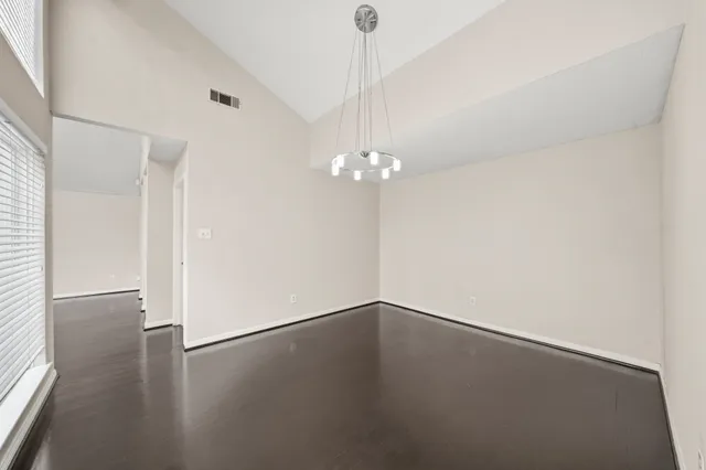 a view of a room with wooden floor and chandelier