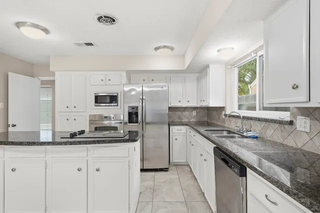a kitchen with stainless steel appliances granite countertop a sink and cabinets