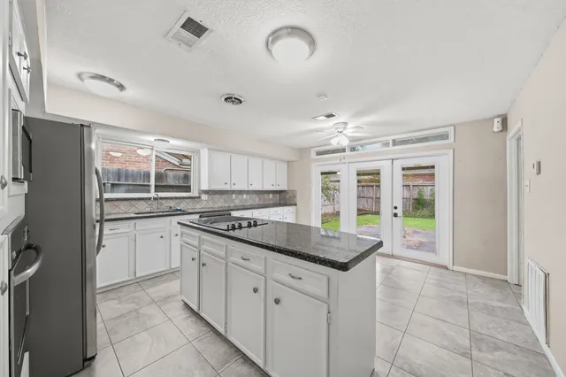 a kitchen with stainless steel appliances granite countertop a stove and a refrigerator