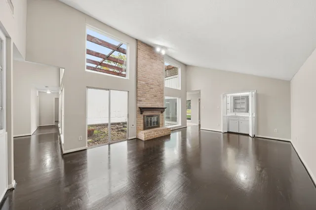an empty room with wooden floor and a fireplace