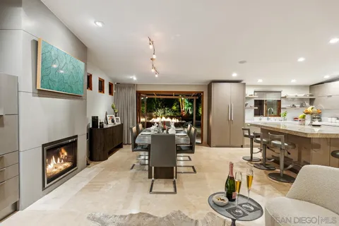 a living room with furniture kitchen view and a fireplace