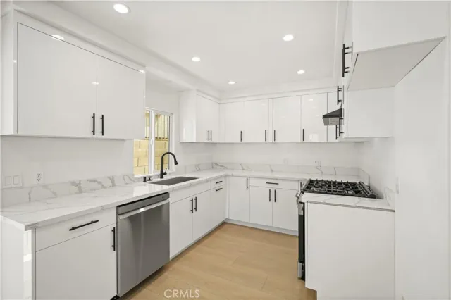 a kitchen with stainless steel appliances granite countertop a sink and cabinets