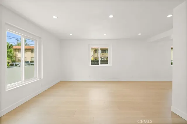 a large kitchen with a large counter top a sink stainless steel appliances and cabinets