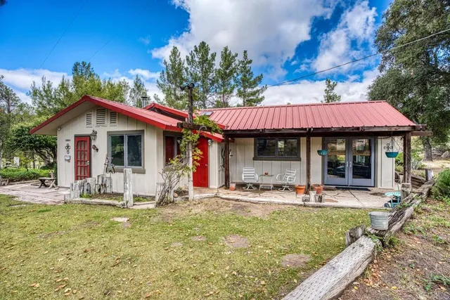 a view of a house with a patio and a yard