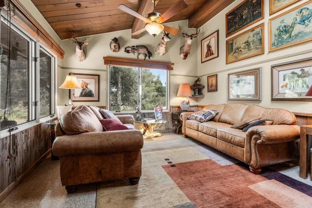 a living room with furniture ceiling fan and a large window