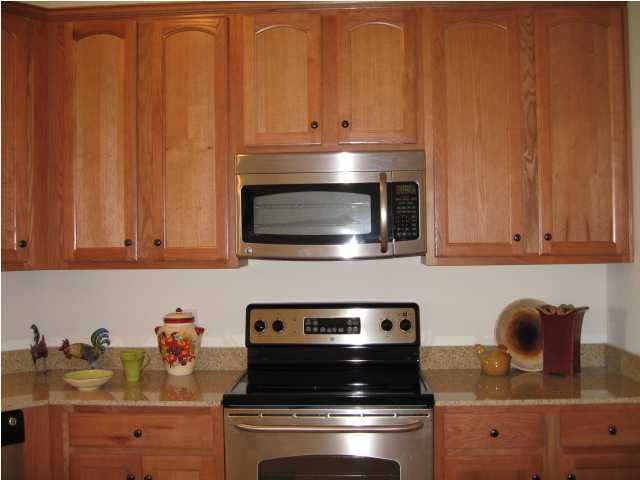 5219 Moore Loop Crestview, FL 32536 - Photo 13 of 14 a kitchen with granite countertop wood cabinets and stainless steel appliances