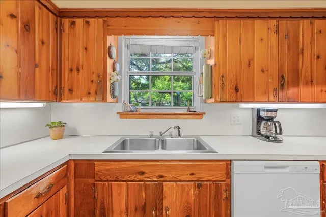 a kitchen with stainless steel appliances wooden cabinets a sink and a window