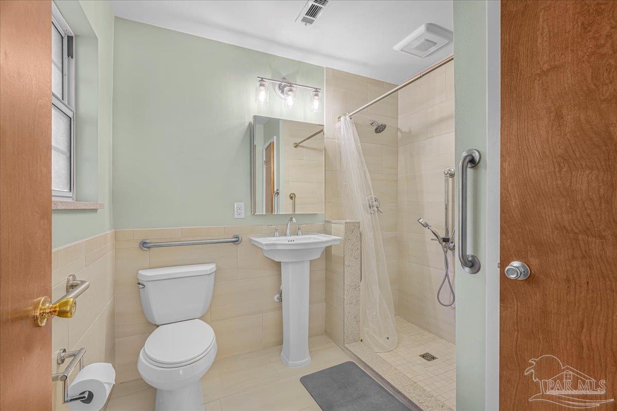 2021 Morningside Drive Pensacola, FL 32503 - Photo 26 of 44 a bathroom with a shower toilet and sink