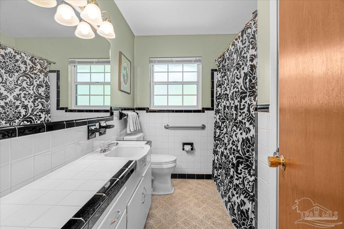 2021 Morningside Drive Pensacola, FL 32503 - Photo 30 of 44 a bathroom with a sink a toilet and a large mirror