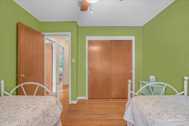 a view of a bedroom with a bed and wooden floor
