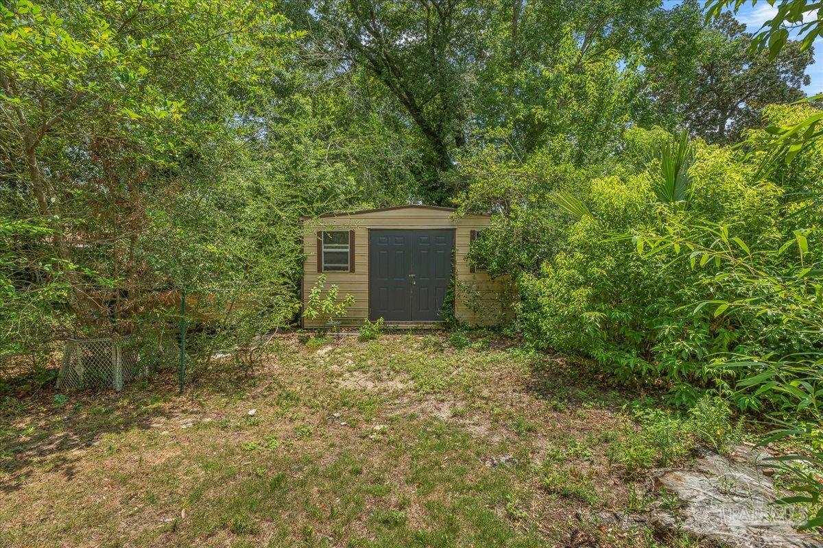 2021 Morningside Drive Pensacola, FL 32503 - Photo 39 of 44 a backyard of a house with plants and large tree