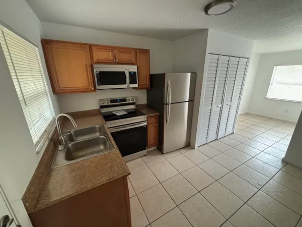 a kitchen with stainless steel appliances a refrigerator sink and microwave