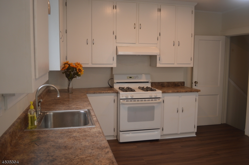5 Gates Avenue Summit, NJ 07901 - Photo 7 of 14 a kitchen with granite countertop white cabinets and white appliances