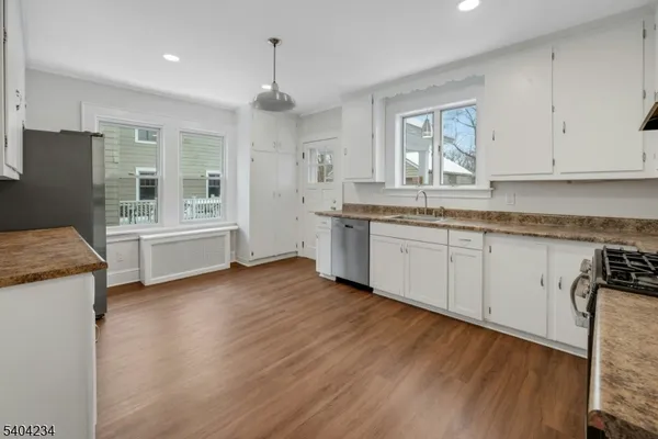 a view of a kitchen counter space a sink wooden floor and a window