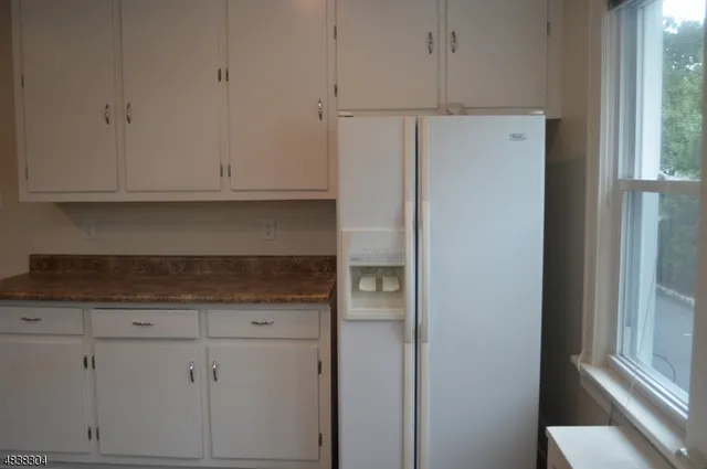 a kitchen with cabinets and a refrigerator