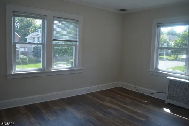 a view of a room with wooden floor and windows in it