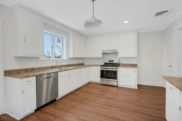 a kitchen with granite countertop white cabinets and white appliances