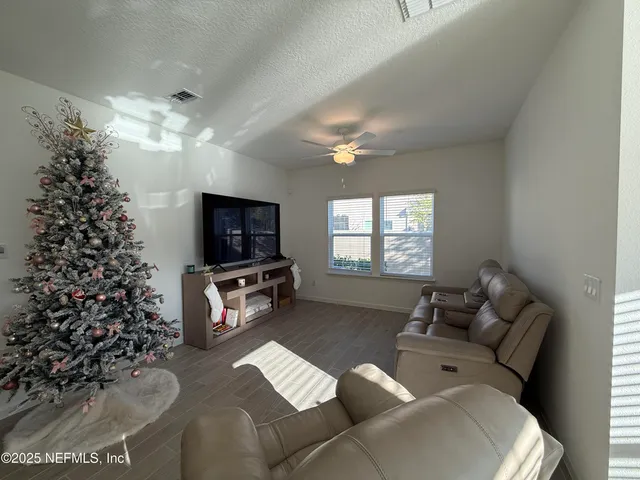 a living room with furniture a window and a flat screen tv