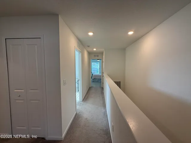 a view of a hallway with a livingroom and a bathroom