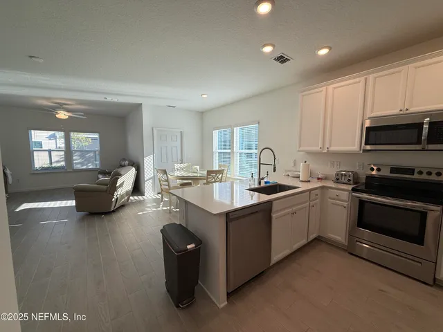 a kitchen with sink a stove and cabinets