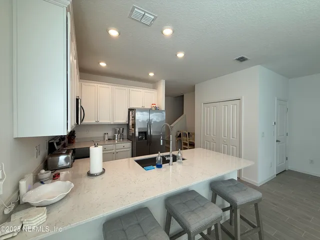 a kitchen with a dining table cabinets and chairs