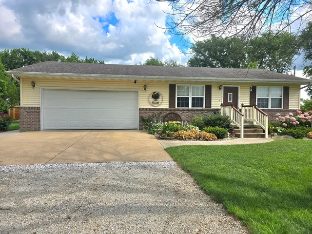 a front view of a house with a garden and plants
