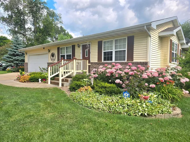 a front view of a house with yard and green space