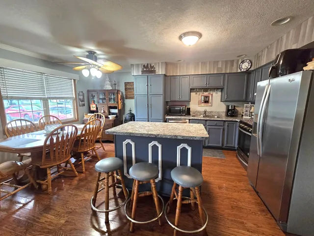 a kitchen with stainless steel appliances a table chairs refrigerator and microwave
