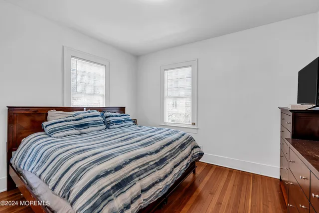 a bedroom with bed and flat tv screen