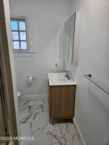 a bathroom with a sink a toilet and a mirror