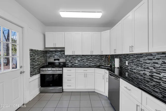 a kitchen with granite countertop a stove sink and cabinets