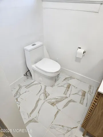 a white toilet sitting next to a shower