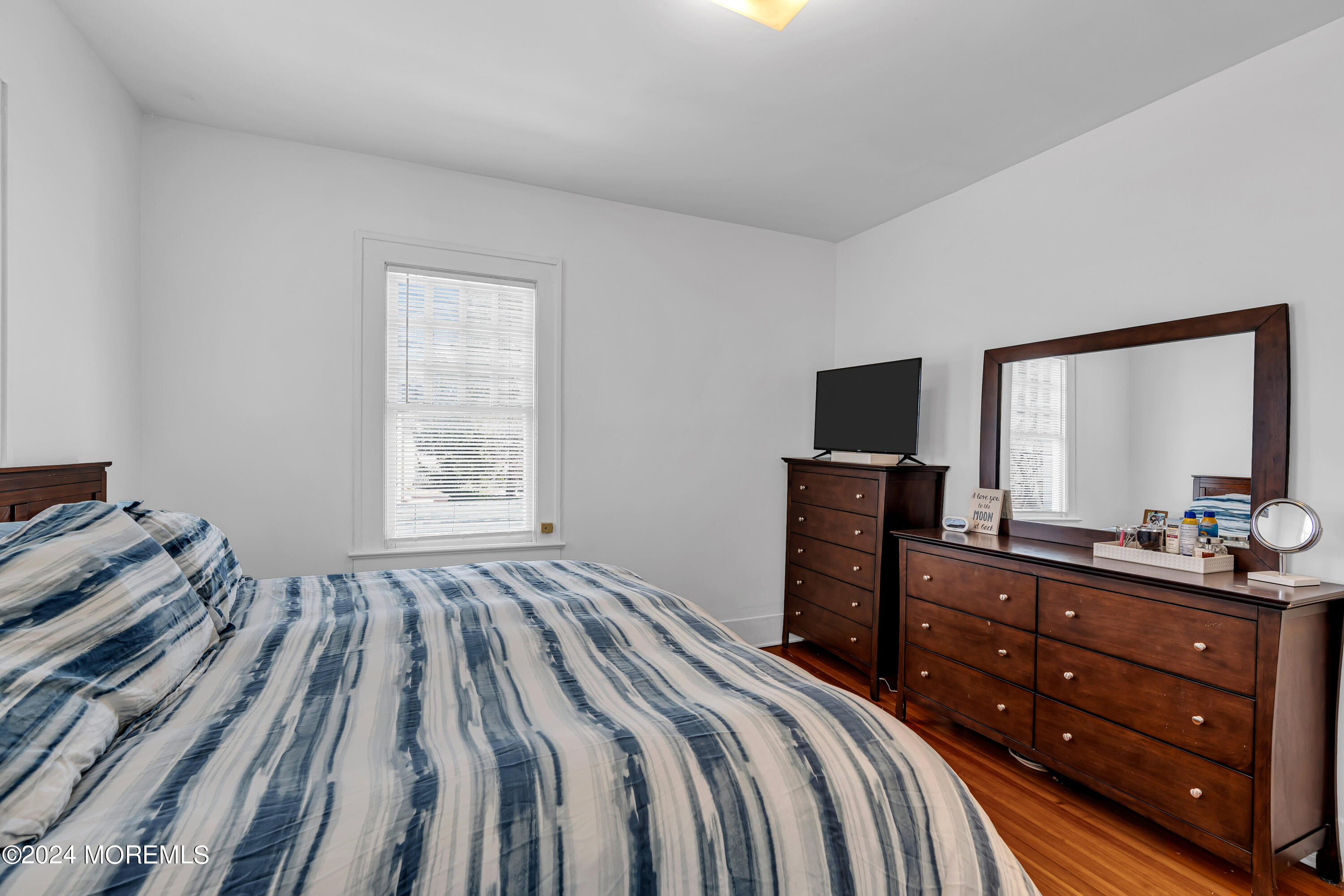 17 Lakeview Road Deal, NJ 07723 - Photo 10 of 30 a bedroom with a bed and a flat tv screen on a dresser