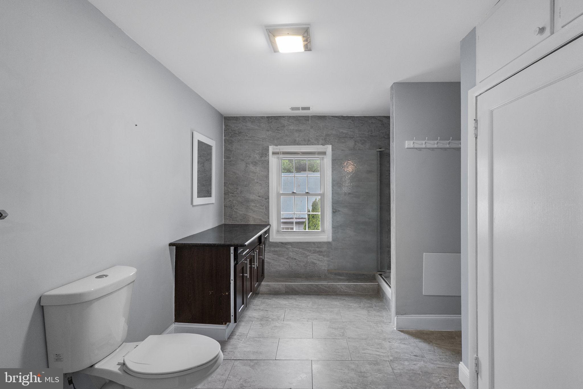 26001 Frederick Road Clarksburg, MD 20871 - Photo 18 of 46 a bathroom with a toilet a sink and mirror