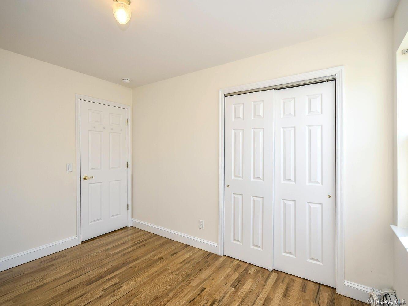 34 Firwood Road, Unit B Port Washington, NY 11050 - Photo 15 of 25 an empty room with wooden floor