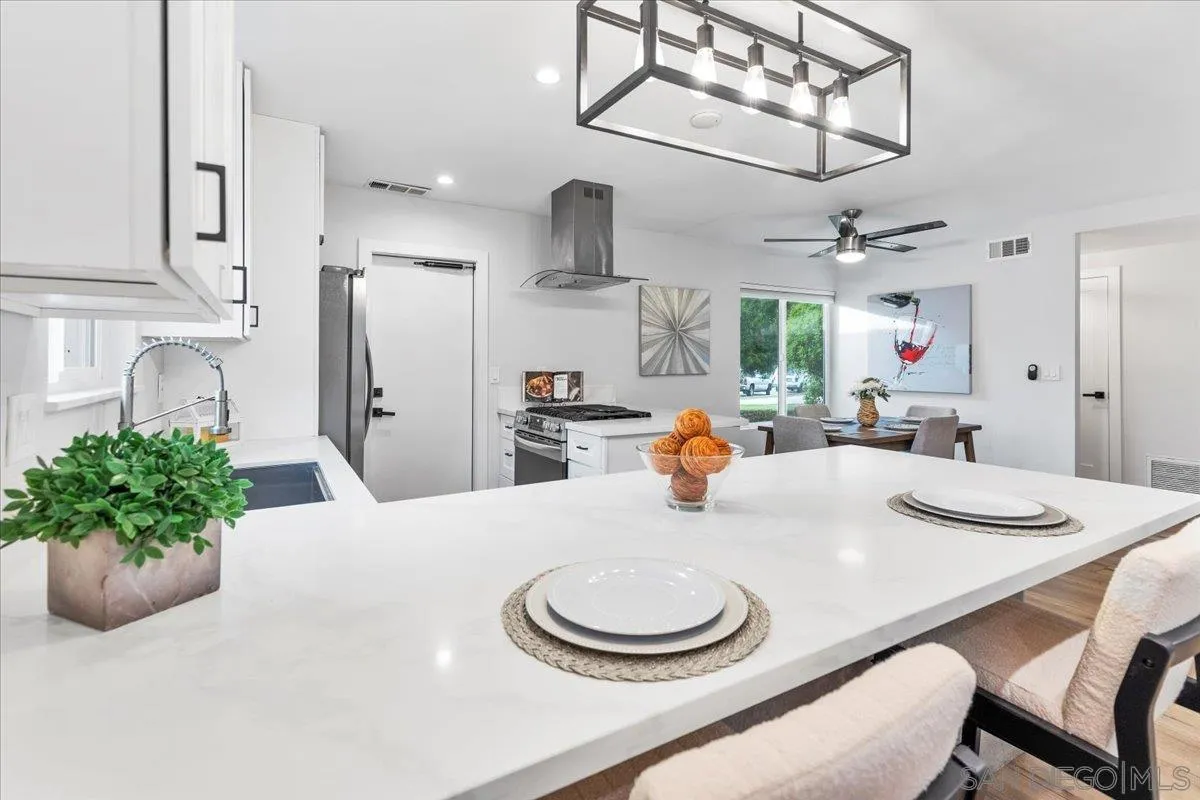 9737 Roe Drive Santee, CA 92071 - Photo 12 of 37 a dining room with stainless steel appliances kitchen island granite countertop furniture and a kitchen view