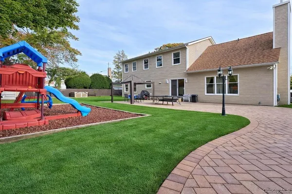 a view of a house with a yard and sitting area