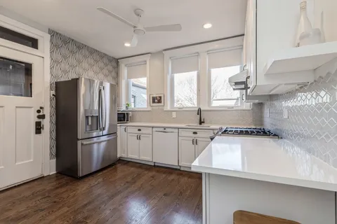 a kitchen with granite countertop a refrigerator stove and sink