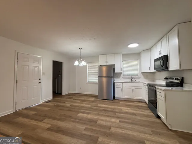 a kitchen with stainless steel appliances a refrigerator stove microwave and sink