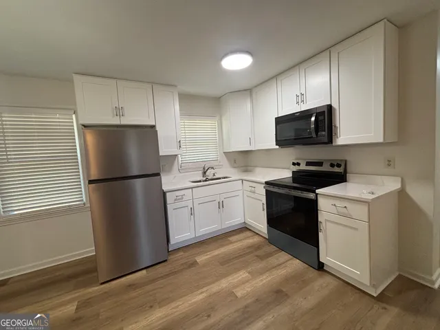 a kitchen with a refrigerator stove and white cabinets