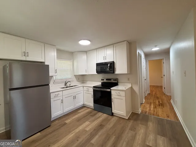 a kitchen with a refrigerator a stove top oven a sink and dishwasher